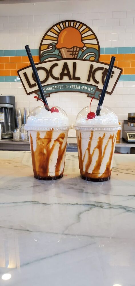 Two caramel shakes on the counter under the Local Ice sign.