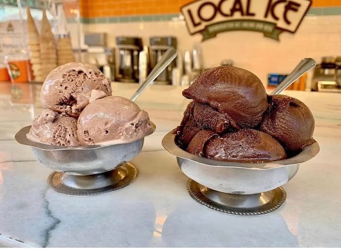 Two silver dishes side by side, one milk chocolate and one dark.